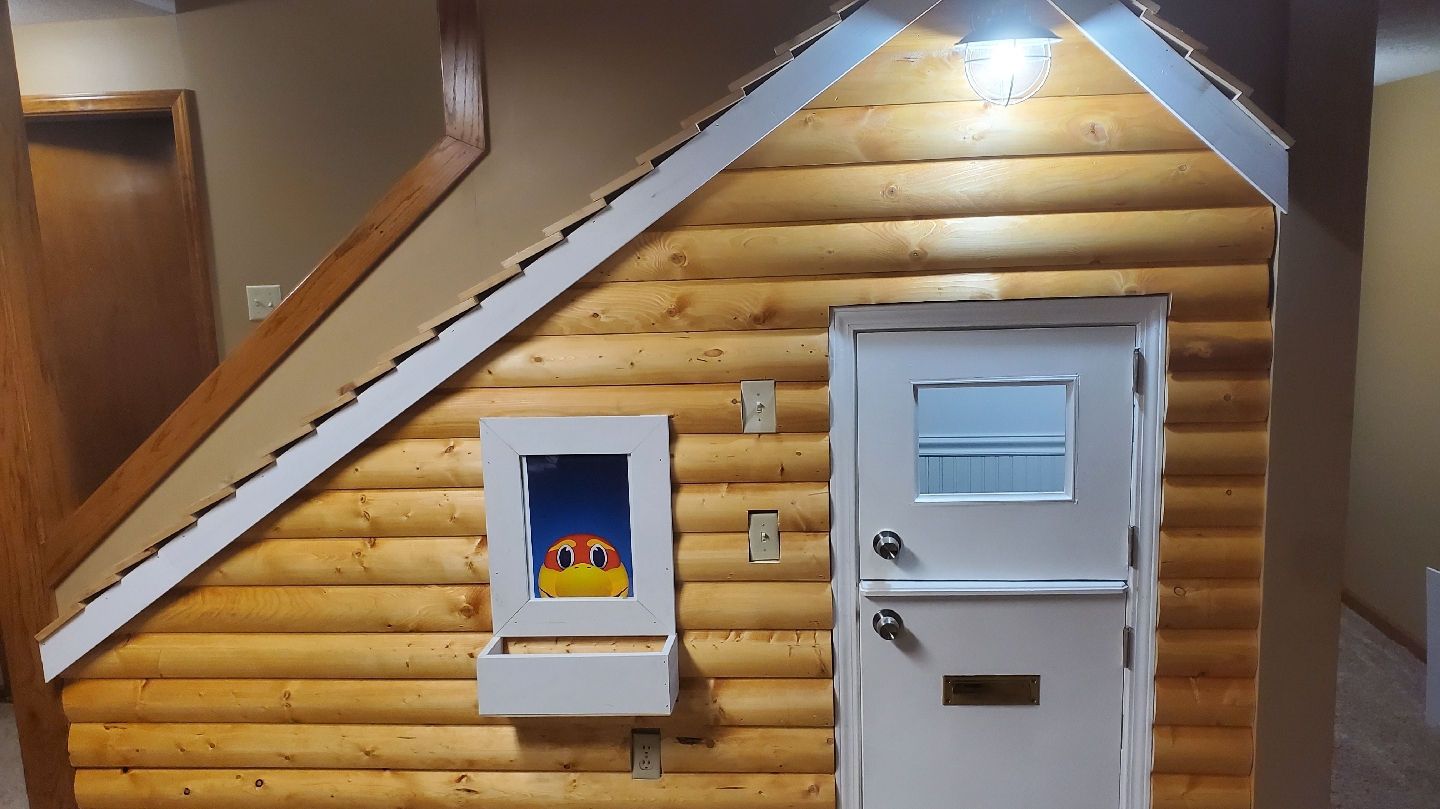 Log-style paneled wall with a door under a staircase