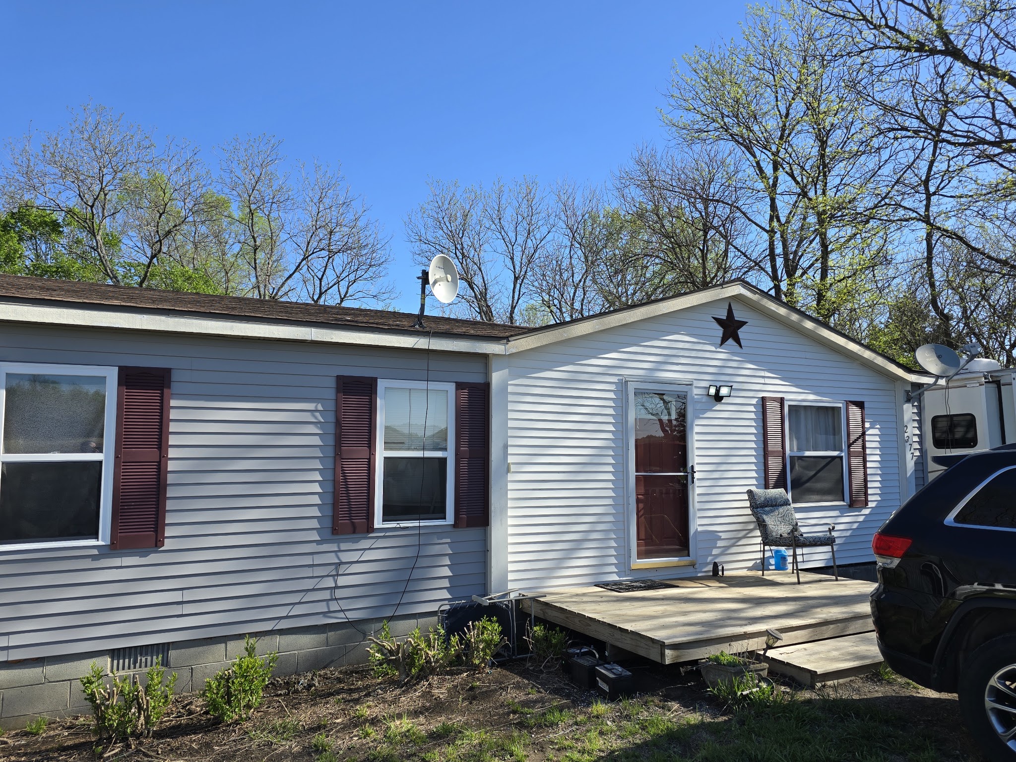Grey vinyl-sided home with a new front deck